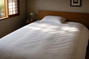 寝室のベッドに掛けた白い高密度生地のカバー